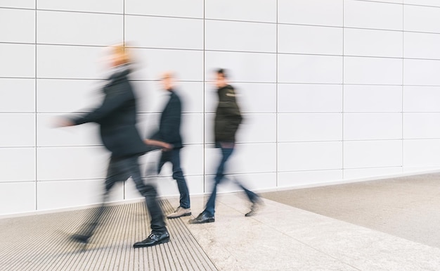 Foto grupo anónimo de empresarios corriendo en un piso en un centro de negocios. ideal para diseños de sitios web y revistas