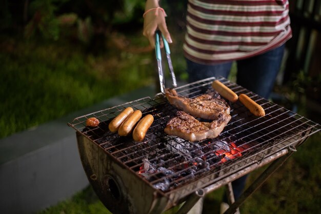 Grupo asiático de amigos com churrasco ao ar livre jardim rindo com bebidas de cerveja alcoólicas