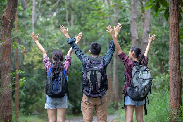 Grupo asiático de jovens caminhadas com mochilas de amigos caminhando juntos e olhando o mapa e takin