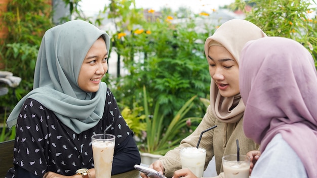 Grupo asiático hijab mujer smilling en café con un amigo