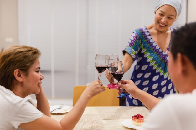 Grupo de asiáticos celebrando una copa de tinto tostado en la cena