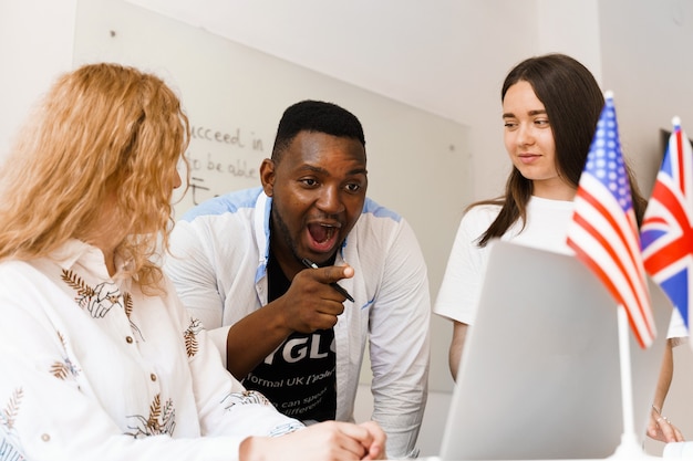 Grupo atraente multiétnico on-line de professores estudam e riem, discutem algo