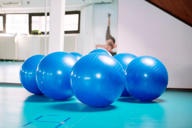 Grupo de bolas de pilates azules en el gimnasio