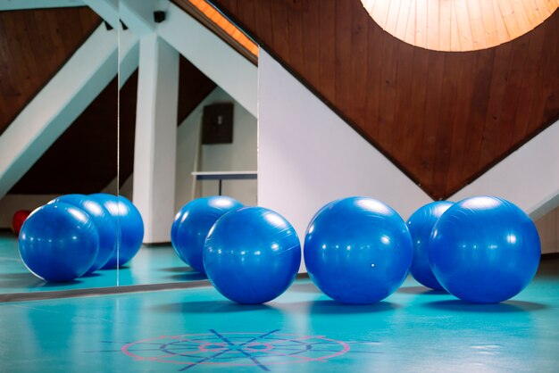 Grupo de bolas de pilates azules en el gimnasio