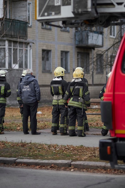 un grupo de bomberos los bomberos están parados cerca de la casa.