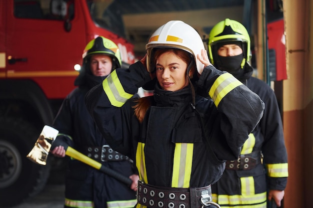 Grupo de bomberos con uniforme protector que está en la estación