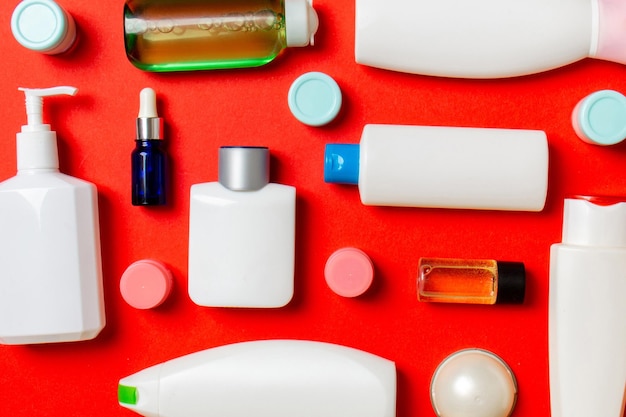 Grupo de botellas plásticas para el cuidado del cuerpo Composición plana con productos cosméticos en fondo de color Espacio vacío para su diseño Conjunto de envases cosméticos blancos Vista superior con espacio de copia