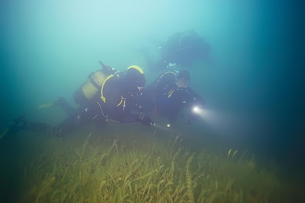 Grupo de buceadores en aguas fangosas poco claras, buceo peligroso