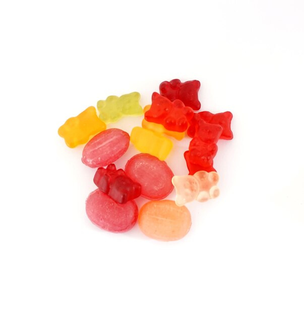 Grupo de caramelos gomosos duros y de gelatina de colores aislados en un concepto de dieta y obesidad de fondo blanco