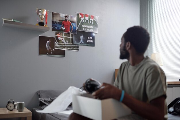 Grupo de carteles con jugadores de fútbol en la pared gris del dormitorio