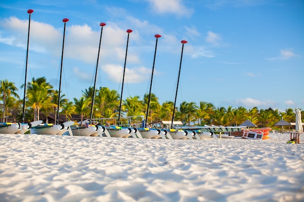 Grupo de catamaranes con velas de colores en la exótica playa caribeña