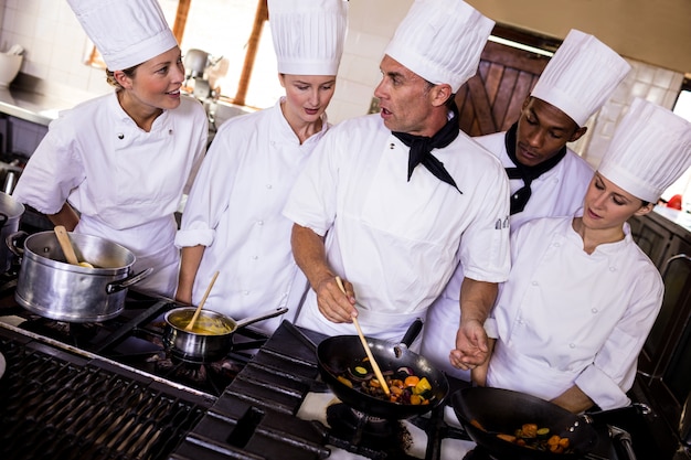 Grupo de chefs preparando la comida en la cocina