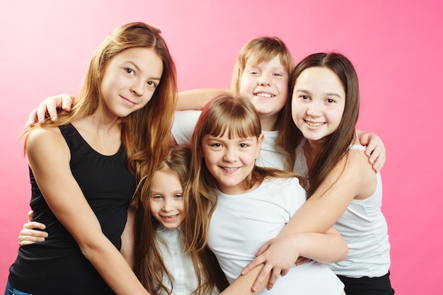 Foto un grupo de chicas adolescentes sobre un fondo rosa.