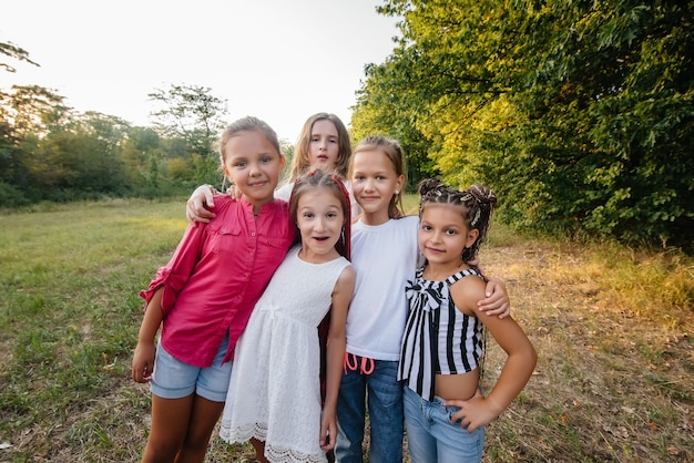 Un grupo de chicas alegres están sonriendo y jugando en el parque durante la puesta de sol