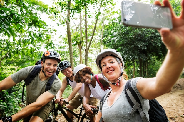 Grupo de ciclistas diversos en el bosque.