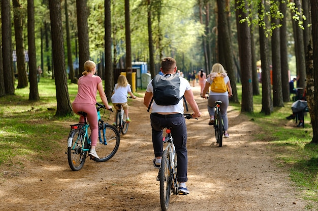 Un grupo de ciclistas con mochilas andan en bicicleta por un camino forestal disfrutando de la naturaleza.