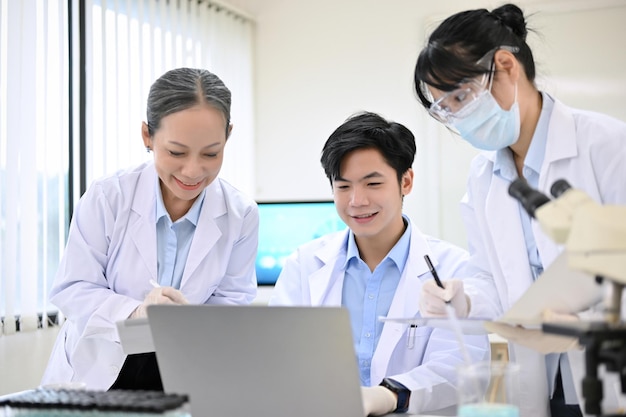 Grupo de un científico o técnico médico asiático trabajando juntos en el laboratorio