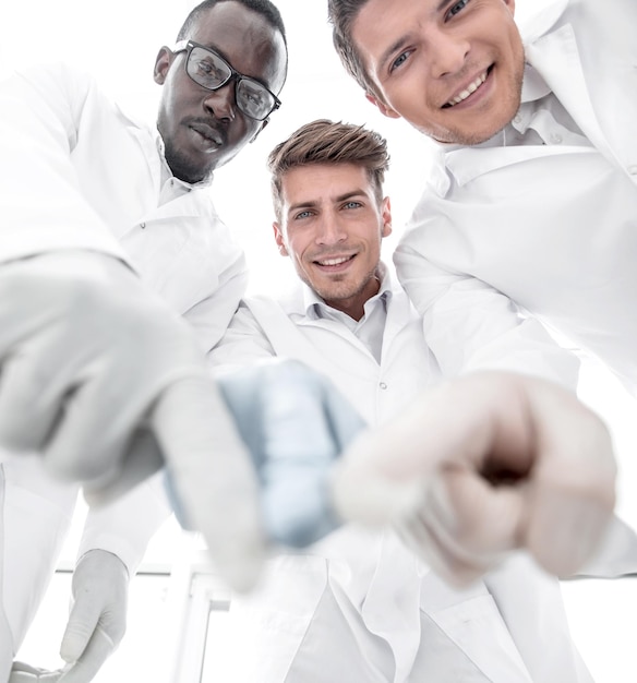 Foto grupo de científicos apuntando a la mesa de laboratorioconcepto de éxito