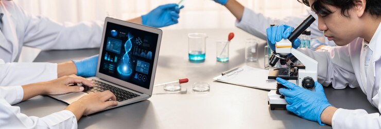 Foto grupo de científicos dedicados que trabajan en software informático de biotecnología avanzada para estudiar o analizar datos de adn después de hacer un avance científico a partir de un experimento químico en un laboratorio médico neotérico