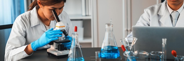 Grupo de científicos dedicados realizan experimentos químicos utilizando microscopio en laboratorio médico para desarrollar nuevas vacunas o antibióticos Concepto de investigación de medicina y laboratorio de biotecnología Neotérico