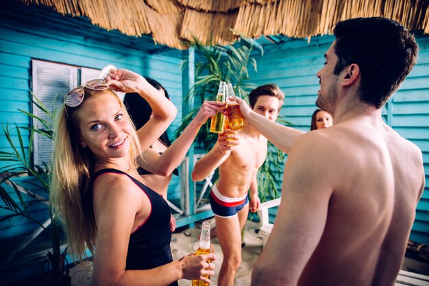 Grupo de cinco amigos celebrando en su casa de playa de verano