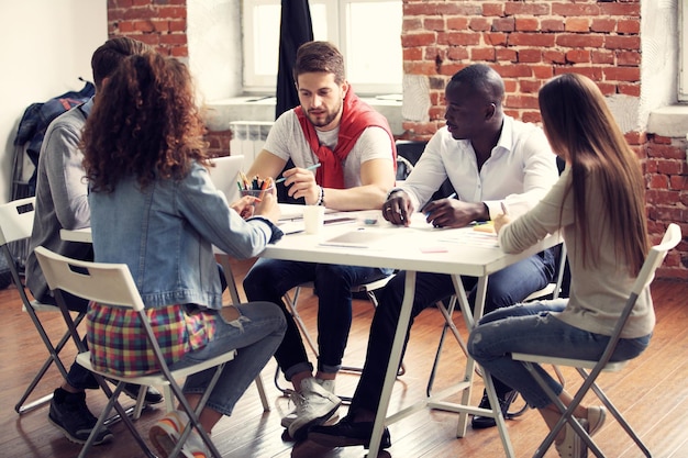 Grupo de cinco trabajadores creativos intercambian ideas juntos en la oficina nuevo estilo de espacio de trabajo escena feliz de personas en la oficina