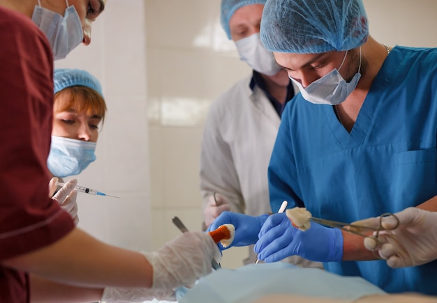 Un grupo de cirujanos haciendo operaciones en un hospital.