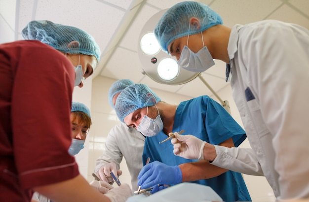 Un grupo de cirujanos haciendo operaciones en un hospital.