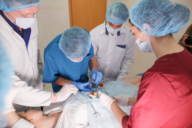 Un grupo de cirujanos que realizan operaciones en un hospital.