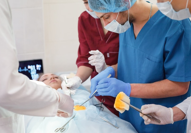 Un grupo de cirujanos que realizan operaciones en un hospital.