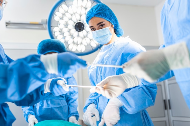 Grupo de cirujanos en quirófano con equipo quirúrgico