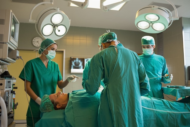 Grupo de cirujanos trabajando en una paciente.