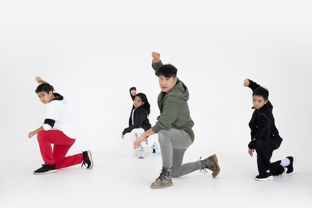 Grupo de clase de baile de actividad de equipo infantil con acción de líder de maestro en fondo blanco de estudio.