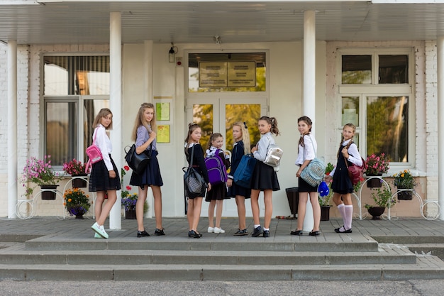 Un grupo de colegialas con mochilas van a la escuela