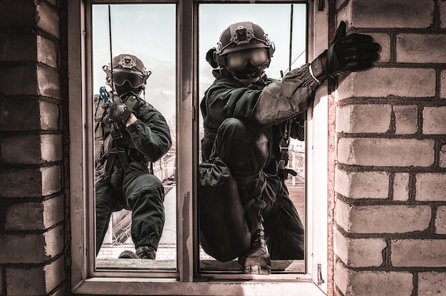 Grupo de combatientes de las fuerzas especiales asaltan el edificio a través de la ventana