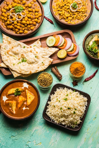 Grupo de comida india como Palak Paneer Butter Masala, Choley o chola y curry de frijoles de ojos negros con naan y arroz