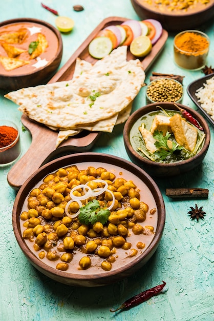 Grupo de comida india como Palak Paneer Butter Masala, Choley o chola y curry de frijoles de ojos negros con naan y arroz