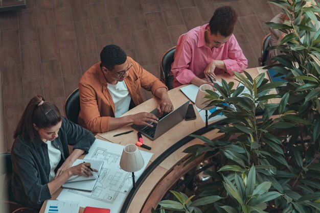 Grupo de compañeros de trabajo que trabajan juntos y hablan en una oficina moderna Lugar de trabajo y concepto de cooperación