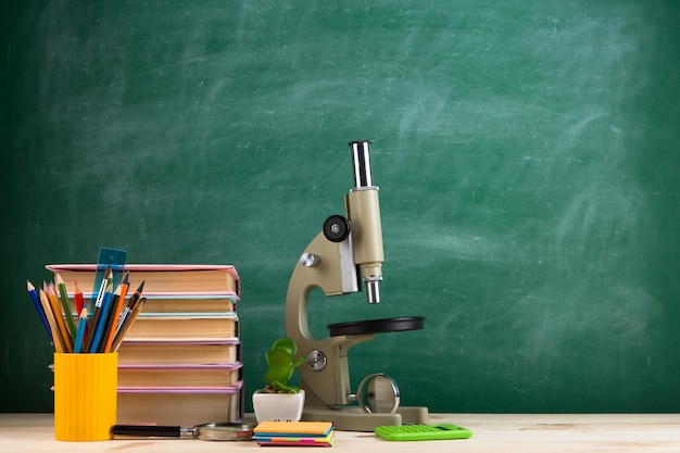 Grupo de concepto de educación y ciencia de libros coloridos y microscopio en la mesa de madera en el aula