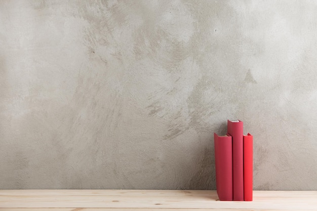 Grupo de concepto de educación y lectura de libros coloridos en la pizarra de pared de hormigón de mesa de madera