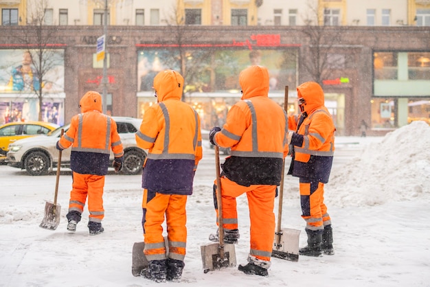 Grupo de conserjes de la ciudad de pie en la calle nevada