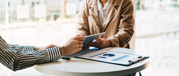 Grupo de consultores de negocios que trabajan con tabletas digitales y gestión de grandes datos y analizan documentos financieros de la empresa