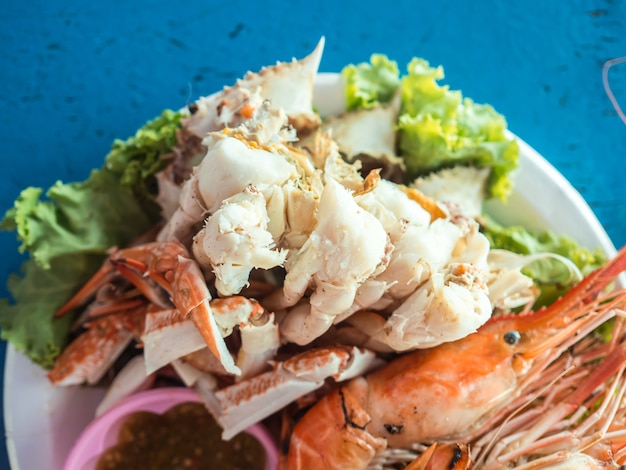 Grupo cozinhado do marisco de camarões e de caranguejos com molho picante em Tailândia.