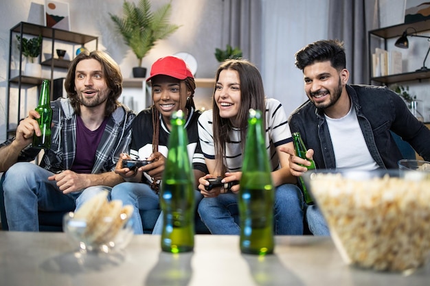 Grupo de cuatro amigos con joysticks jugando videojuegos