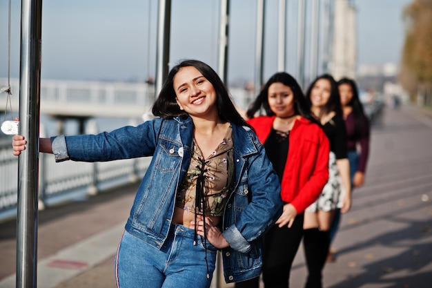 Grupo de cuatro chicas latinas felices y bonitas de Ecuador posaron en la calle