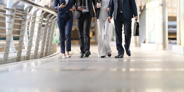 Un grupo de cuatro empresarios caminando y hablando entre ellos.