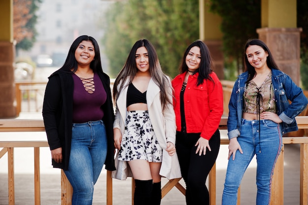 Un grupo de cuatro muchachas latinas felices y bonitas de Ecuador posó en la calle.