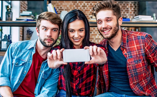 Grupo das melhores jovens amigas lindas enquanto relaxa no sofá e se diverte