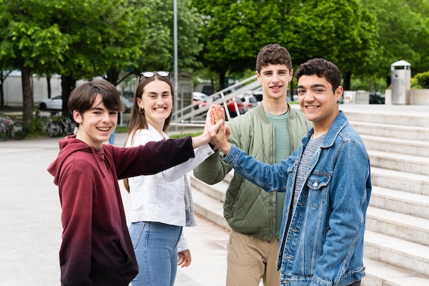 Grupo de adolescentes dando mais cinco ao ar livre