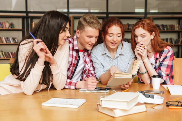 Grupo de adolescentes empolgados fazendo lição de casa